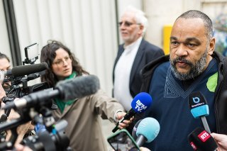 L'humoriste Dieudonné face aux sollicitations des médias avant d'entrer au Palais de justice de Genève.